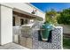 Outdoor kitchen featuring stainless steel appliances, a built-in grill, and stylish tile work at 7838 N 54Th Pl, Paradise Valley, AZ 85253
