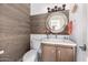 Stylish powder room features wood accent wall, decorative mirror, and patterned tile floor at 7838 N 54Th Pl, Paradise Valley, AZ 85253