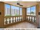 Bright enclosed balcony featuring a ceiling fan, tiled floor, and scenic views of the community's landscaped exterior at 7970 E Camelback Rd # 110, Scottsdale, AZ 85251