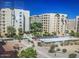 A daytime exterior view of a multi-story apartment complex with community pool and desert landscaping at 7970 E Camelback Rd # 110, Scottsdale, AZ 85251