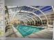 View of an indoor pool area with a vaulted glass ceiling and multiple lounge chairs at 7970 E Camelback Rd # 110, Scottsdale, AZ 85251