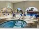 View of the pool and hot tub area with lounge seating, archways, and partial view of building at 7970 E Camelback Rd # 110, Scottsdale, AZ 85251