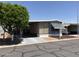 View of mobile home featuring covered parking, tidy landscaping and low maintenance yard for easy care at 8700 E University Dr # 1450, Mesa, AZ 85207