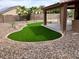 Well-maintained backyard featuring a putting green, rock landscaping and covered patio at 8732 W Adam Ave, Peoria, AZ 85382