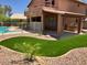 Landscaped backyard with covered patio, outdoor kitchen, and swimming pool view at 8732 W Adam Ave, Peoria, AZ 85382