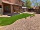 Backyard view featuring synthetic grass, rock landscaping, patio area, and storage shed at 8732 W Adam Ave, Peoria, AZ 85382