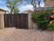 A backyard entrance through a rustic wooden gate and gravel landscaping at 8732 W Adam Ave, Peoria, AZ 85382
