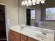 Bright bathroom featuring a double sink vanity, and a large mirror at 8732 W Adam Ave, Peoria, AZ 85382