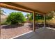 Covered patio featuring lattice screens overlooks a backyard with desert landscaping and trees at 9123 W Utopia Rd, Peoria, AZ 85382