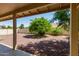 A covered patio overlooks a well-kept backyard featuring desert landscaping and a mature citrus tree at 9123 W Utopia Rd, Peoria, AZ 85382