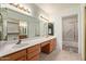 Well-lit main bathroom features dual sinks, large mirror and walk-in shower at 9123 W Utopia Rd, Peoria, AZ 85382