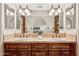 Elegant bathroom with a dual sink vanity, decorative mirrors and an arched doorway at 9460 N 105Th Pl, Scottsdale, AZ 85258