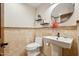 Tastefully appointed half bathroom featuring tile walls, pedestal sink, and wood accents at 9460 N 105Th Pl, Scottsdale, AZ 85258