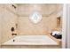 Bathroom featuring a bathtub with tan tile surround, stained glass art, and bronze faucet at 9460 N 105Th Pl, Scottsdale, AZ 85258