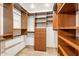 Spacious walk-in closet with custom wood shelving, drawers and storage, providing optimal organization at 9460 N 105Th Pl, Scottsdale, AZ 85258