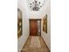 Inviting entryway showcasing a beautiful wood front door, elegant light fixture, and tiled floors at 9460 N 105Th Pl, Scottsdale, AZ 85258