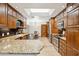 Well-equipped kitchen featuring custom cabinets, granite counters, and a bright skylight at 9460 N 105Th Pl, Scottsdale, AZ 85258