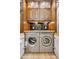 Convenient laundry room featuring custom cabinetry and stainless steel washer and dryer at 9460 N 105Th Pl, Scottsdale, AZ 85258