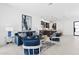Open-concept living room with plush blue seating, neutral tile flooring, and a view of the modern kitchen area at 1 Easy St # 15, Carefree, AZ 85377