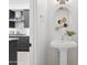 Bright powder room featuring a pedestal sink, decorative mirror, and modern fixtures adjacent to the gray and white kitchen at 1 Easy St # 15, Carefree, AZ 85377