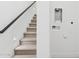 Staircase with carpeted steps and a dark wood handrail, featuring adjacent wall with hookups at 1 Easy St # 15, Carefree, AZ 85377