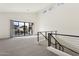 Spacious loft with high ceilings, modern railing, neutral carpet, and sliding doors to balcony at 1 Easy St # 4, Carefree, AZ 85377