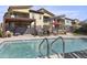 A community pool with desert landscaping, sun umbrellas, and lounge chairs at 1 Easy St # 4, Carefree, AZ 85377