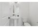 Clean powder room with white walls, pedestal sink, and matching toilet at 1 Easy St # 5, Carefree, AZ 85377