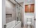 Bathroom featuring a bathtub with shower, glass partition and wood cabinets at 10101 N Arabian Trl # 1005, Scottsdale, AZ 85258