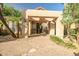 Charming clubhouse entrance with stone accents, covered walkway, and tropical landscaping in a welcoming community setting at 10101 N Arabian Trl # 1005, Scottsdale, AZ 85258