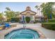 Community hot tub surrounded by blue seating, lush landscaping, and a charming cabana perfect for relaxation at 10101 N Arabian Trl # 1005, Scottsdale, AZ 85258