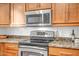 Updated kitchen featuring stainless steel microwave, stove, oven, and granite counters at 10101 N Arabian Trl # 1005, Scottsdale, AZ 85258