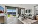 Bright living room with neutral color palette, modern light fixture and sliding glass doors at 10544 W Bloch Rd, Tolleson, AZ 85353