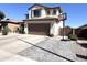 A suburban home featuring a two-car garage, neutral stucco, desert landscaping, and basketball hoop at 11121 E Sombra Ave, Mesa, AZ 85212