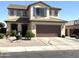 Inviting two-story home featuring a two-car garage, neutral stucco, desert landscaping, and shuttered windows at 11121 E Sombra Ave, Mesa, AZ 85212