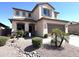 Inviting two-story home featuring a two-car garage, neutral stucco, desert landscaping, and shuttered windows at 11121 E Sombra Ave, Mesa, AZ 85212