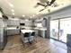 Bright, airy kitchen with gray cabinetry, a center island with seating, stainless steel appliances, and sliding glass doors to patio at 11121 E Sombra Ave, Mesa, AZ 85212