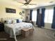 Cozy main bedroom featuring carpeted floors, a ceiling fan, and two bright windows at 11121 E Sombra Ave, Mesa, AZ 85212