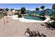 Inviting backyard swimming pool with surrounding rock landscaping and privacy fencing at 11121 E Sombra Ave, Mesa, AZ 85212