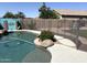 Backyard swimming pool with a safety fence surrounded by rock landscaping at 11121 E Sombra Ave, Mesa, AZ 85212
