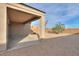 An outdoor covered patio with a gravel backyard and a partial view of nearby homes at 1127 E Tyler Ln, Casa Grande, AZ 85122