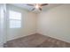 Comfortable bedroom featuring plush carpeting, a ceiling fan, and a large window for ample natural light at 1127 E Tyler Ln, Casa Grande, AZ 85122
