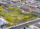 Aerial view of park with a playground and open field surrounded by a walking path at 1127 E Tyler Ln, Casa Grande, AZ 85122