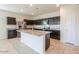 This spacious kitchen features a central island, stainless steel appliances, and dark cabinetry at 1127 E Tyler Ln, Casa Grande, AZ 85122