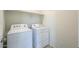 Efficient laundry room featuring a white washer and dryer, plus built-in shelving for organized storage at 1127 E Tyler Ln, Casa Grande, AZ 85122