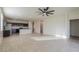 Open-concept living room with tile flooring flowing into kitchen with modern appliances and breakfast bar at 1127 E Tyler Ln, Casa Grande, AZ 85122