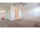 Spacious main bedroom with soft carpet, ceiling fan, and ensuite bathroom and walk-in closet access at 1127 E Tyler Ln, Casa Grande, AZ 85122