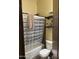 Cozy bathroom featuring a toilet, shelving unit, and a shower with a striped curtain, providing both functionality and comfort at 12937 W Calle De Sol --, Peoria, AZ 85383