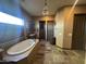 Bright bathroom features a soaking tub, decorative chandelier, and dual vanities at 12937 W Calle De Sol --, Peoria, AZ 85383
