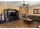 Cozy living room with a stone fireplace, entertainment center, and leather sofa at 12937 W Calle De Sol --, Peoria, AZ 85383
